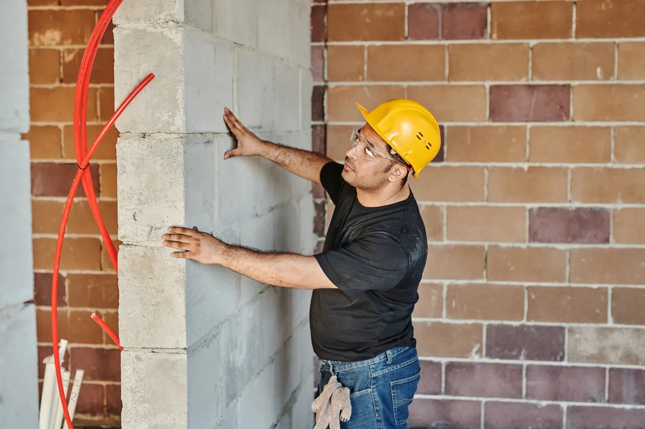 Certified radon mitigation technician inspecting a foundation wall in Sioux Falls, SD